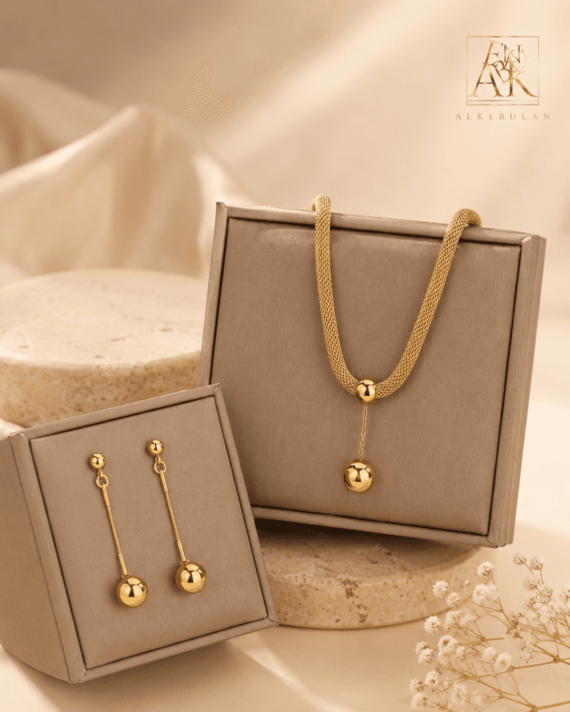 Alkebulan Gold Drops halsband och örhängen i guldton i beige askar