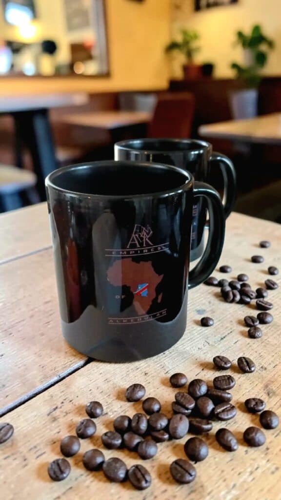 Två svarta Alkebulan-muggar med Afrikas karta och kaffebönor