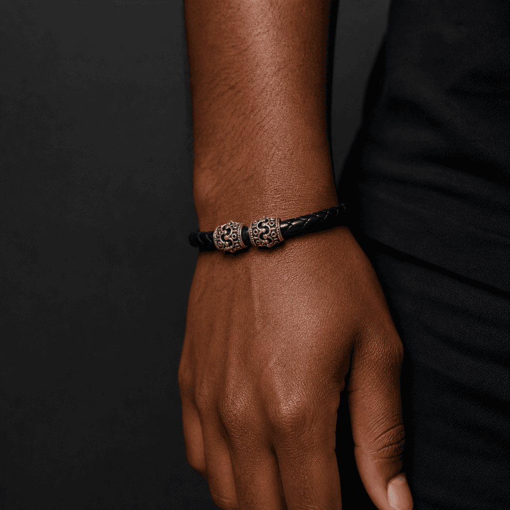 Svart flätat läderarmband med silverkronor på handled